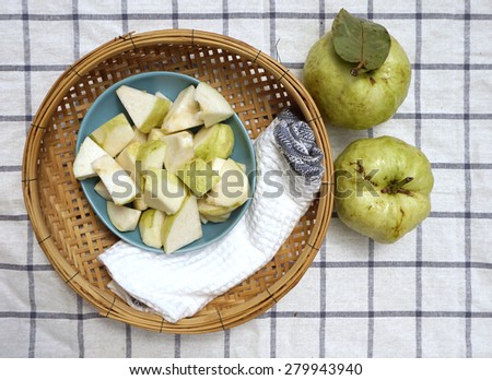top view of fresh guava fruit with white napkin on woven basket