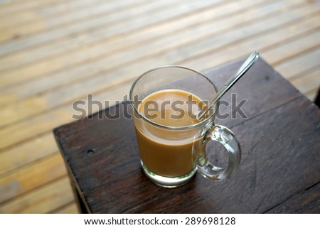 Hot coffee on timber table with timber floor background