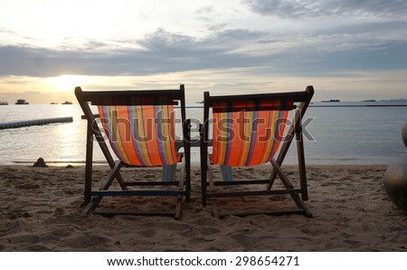 Orange color canvas beach bed at the beach with sunset background at the twilight time