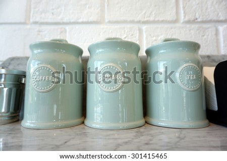pastel color coffee, tea and sugar ceramic jar  on marble top and brick wall background