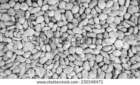 Naturally polished white rock pebbles background, black and white