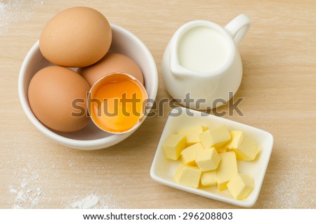Food ingredient,recipe (egg yolk,milk,butter) for backing (cake,dessert,sweet,) on wooden background