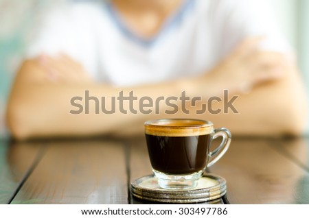 The cup of coffee (espresso) on the wooden table in the coffee shop and ready to drink