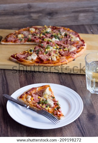 pizza with sausage, chicken, corn and cheese