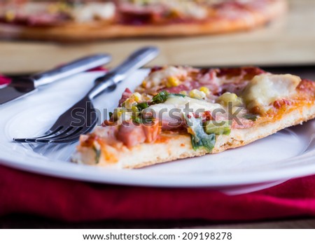 pizza with sausage, chicken, corn and cheese
