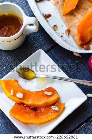 baked pumpkin slices with cinnamon and nuts, spoon with honey ,healthy dessert