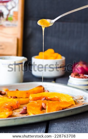pour honey roasted pumpkin slices with cinnamon on parchment,vegan dessert, hands
