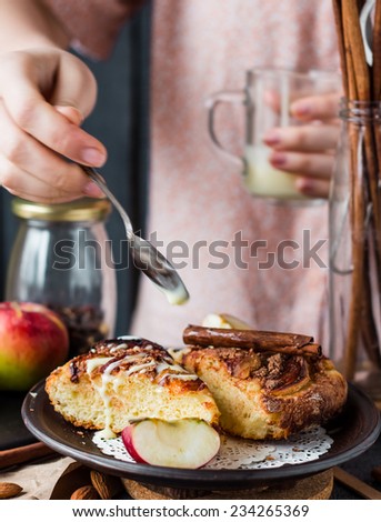 apple pie with apples and cinnamonÃ?Â?Ã?Â watering condensed milk on a wooden board, hands