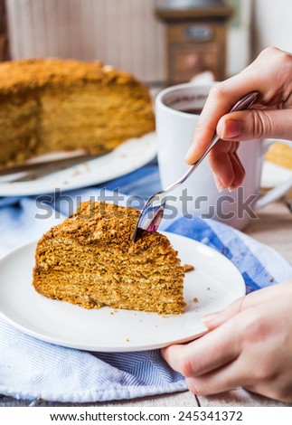 eating honey cake with sour cream and nuts, hand,sweet dessert