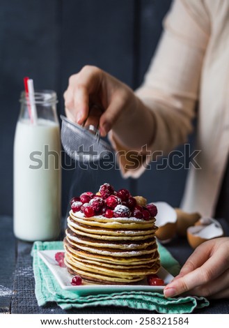 Pancake with cranberries and raspberries sprinkled with powdered hands, dessert, american kitchen