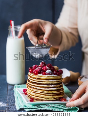 Pancake with cranberries and raspberries sprinkled with powdered hands, dessert, american kitchen