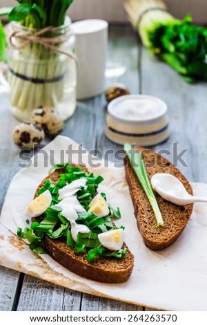 rye bread with wild garlic, sour cream and quail eggs, snack, toast on the gray board