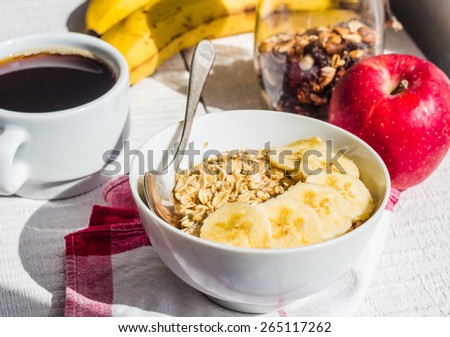 oatmeal with bananas, apples, nuts and dried fruit jar, cup of coffee, healthy breakfast