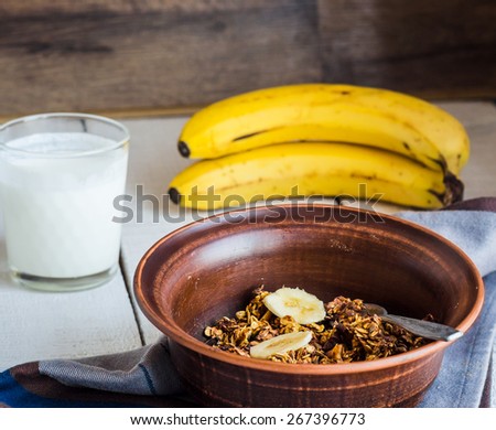 banana granola with nuts, figs and honey in a white piala, clean eating