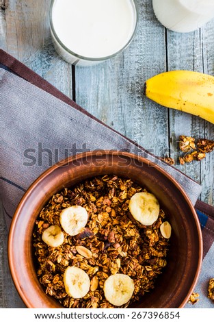 granola with bananas, nuts, figs and honey, milk, healthy breakfast on a gray background