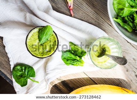 Vitamin green smoothie with spinach leaves, banana and peanut milk, clean eating, on gray wooden background