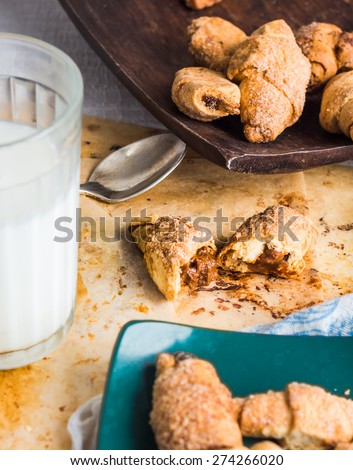 bagels biscuits from short pastry stuffed with condensed milk in a wooden plate, a glass of milk, dessert on white background