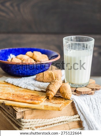 bagels biscuits from a short pastry with filling, milk, in the blue plate sweet pastries on a wooden background
