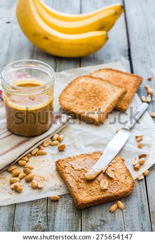 crispy toast with peanut butter, bananas, breakfast on the wooden background