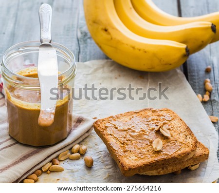 crispy toast with peanut butter, bananas, breakfast on the wooden background