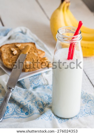 banana smoothie, toast with peanut butter, roasted peanuts, breakfast on a light background