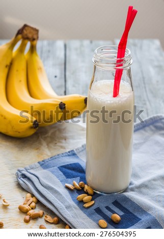 banana cocktail with peanut butter, roasted peanuts, drink on a light background