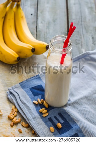 banana cocktail with peanut butter, roasted peanuts, drink on a light background