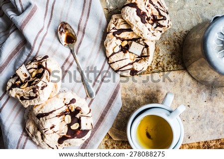 meringue cake with chocolate, caramel and nuts, dessert, rustic, french cuisine,top view