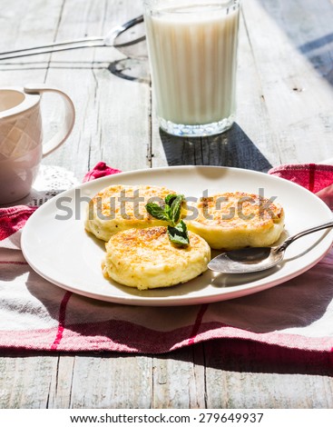 cottage cheese pancakes with mint and powdered sugar, a glass of milk and honey, breakfast