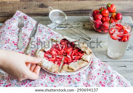 eating a piece of rye biscuit with fresh strawberries, summer pie, hands, clean\
eating