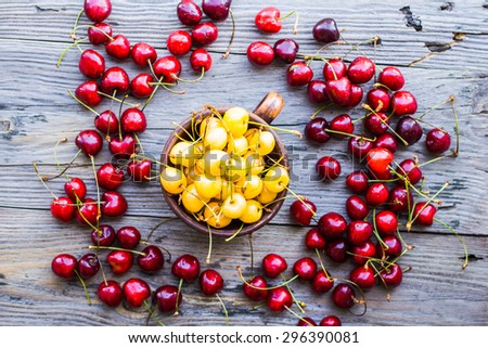 fresh red cherry in a plate on a gray wood background,
healthy snack, summer berries, top view