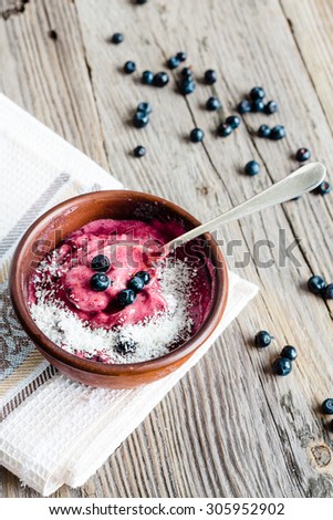 banana ice cream with blueberries and coconut flakes, healthy dessert, vegan breakfast, rustic background