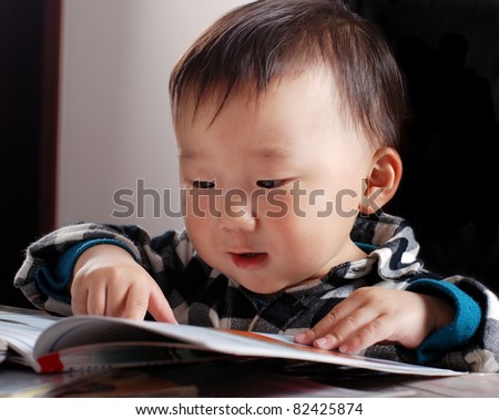 little asian boy reading book