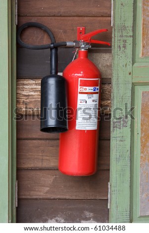 red extinguisher hang on wood wall