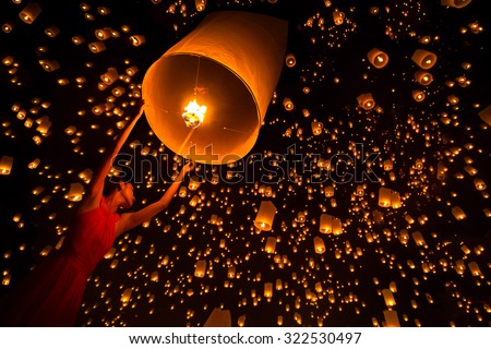 Young woman release sky lanterns to worship buddha\'s relics in yi peng festival, Chiangmai thailand