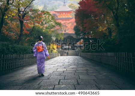 Japanese woman walking to red pagoda, Japan