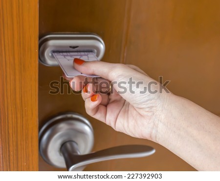 woman\'s hand inserting key card in an electronic lock