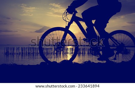 silhouette of the cyclist riding a road bike at sunset