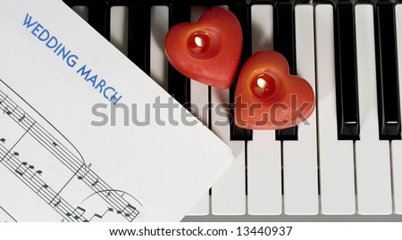 Piano keys with two heart-shaped candles and sheet music (Wedding March)