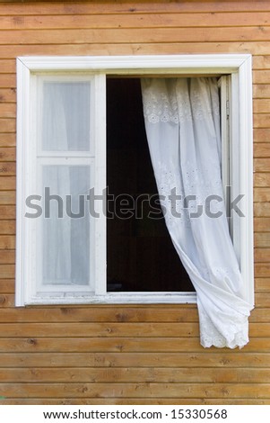 Old traditional country-style window in a wooden house (with a white curtain)