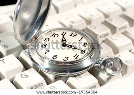Ancient pocket watch on the computer keyboard