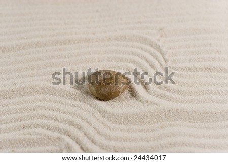 Closeup of a pebble on white sand (Zen style)