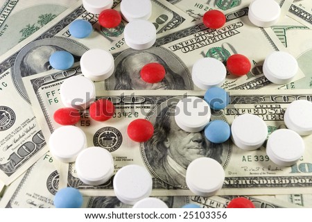 Closeup of white, red and blue pills on a bunch of US dollars