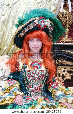 Smiling red-haired teenage girl wearing an antique princess dress and hat (sitting on a princess throne)