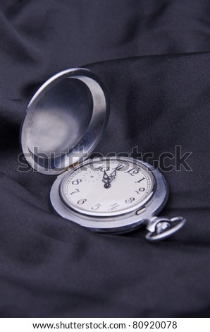 Antique pocket watch on a black silk background