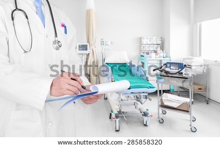 Doctor writing a medical prescription in hospital room