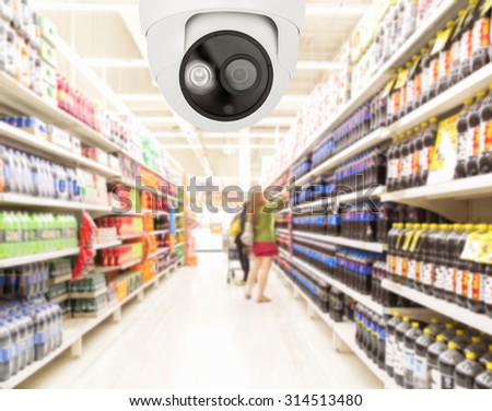 Modern security camera on monitoring the supermarket with blurred background