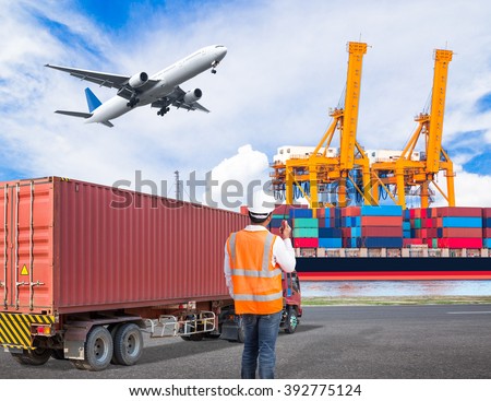 Dock worker talking with radio for controlling loading container in an industrial harbor with truck transport container and cargo plane flying above ship port for logistic import export concept