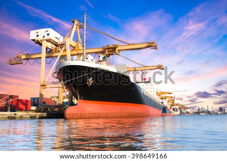 Container cargo freight ship with working crane loading bridge in shipyard at twilight for logistic Import export background
