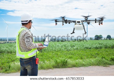 Technician farmer use wifi computer control agriculture drone on sugarcane field